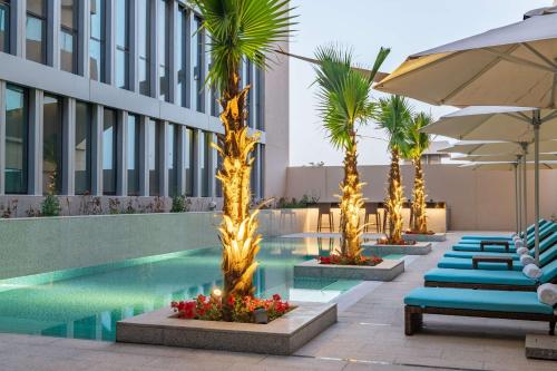 利雅德Park Inn by Radisson, Riyadh的酒店游泳池设有躺椅和遮阳伞