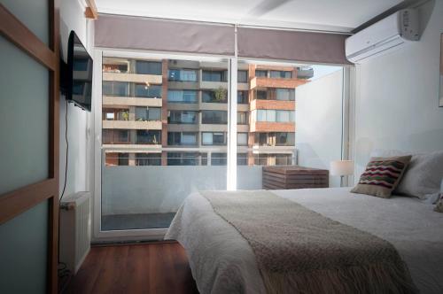 圣地亚哥Las Condes, Excelentes Apartamentos - Sofia Camilla Propiedades的一间卧室设有一张床和一个大窗户