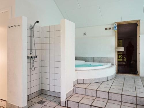 维斯特索马肯12 person holiday home in Aakirkeby的一间带浴缸和淋浴的浴室
