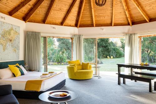 玛拉豪Abel Tasman Lodge的一间卧室配有一张床、一张沙发和一张桌子