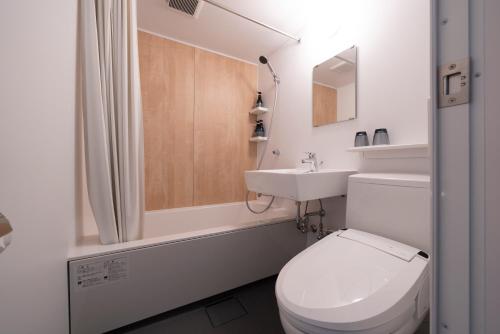 福冈Hotel Oriental Express Fukuoka Tenjin的白色的浴室设有卫生间和水槽。