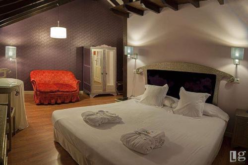 柯米拉斯Posada torre del milano的一间卧室配有一张大床和毛巾