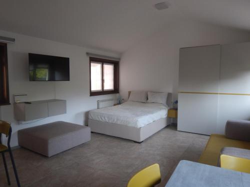 西斯蒂亚纳Appartamento SG的一间卧室配有一张床、一台电视和一张沙发