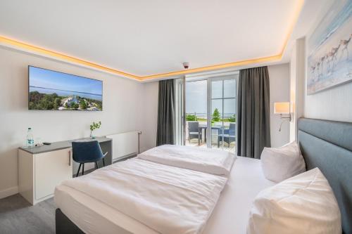 萨斯尼茨Hotel Königslinie的配有一张床和一张书桌的酒店客房