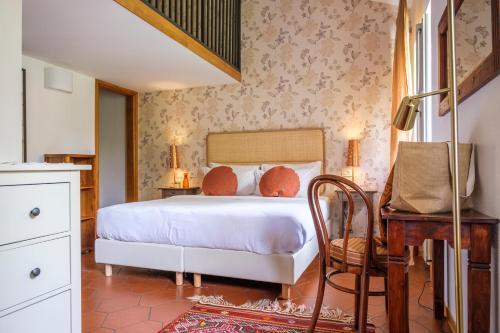 杜伊诺博尔戈杜伊诺别墅酒店的一间卧室配有一张床、一张桌子和一把椅子