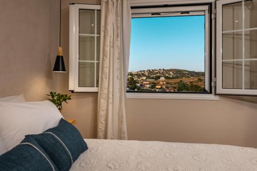 沃丽曼村Vardakis house的一间卧室设有一张床和一个美景窗户。