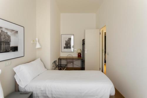米兰Ca' Brera的卧室配有白色的床和桌子