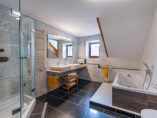 涅德劳Ferienwohnung Neuheim的浴室配有2个盥洗盆、浴缸和淋浴。