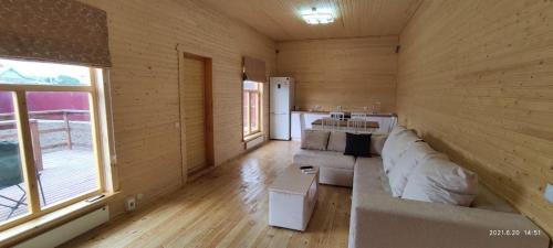 博罗沃耶ZHANUYA HOUSE的木制客厅设有白色沙发