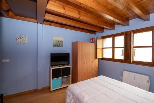 涅姆布罗Casa Mariví的一间卧室配有一张床和一台平面电视