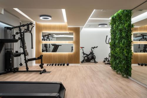 雅典LUX&EASY Athens Downtown Apartments的健身房设有健身器材和绿色的墙壁