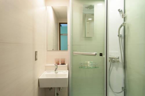 东京Agora Place Tokyo Asakusa的白色的浴室设有水槽和淋浴。