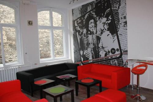 波兹南波兹南拉古塔拉旅馆的客厅配有黑色和红色的沙发