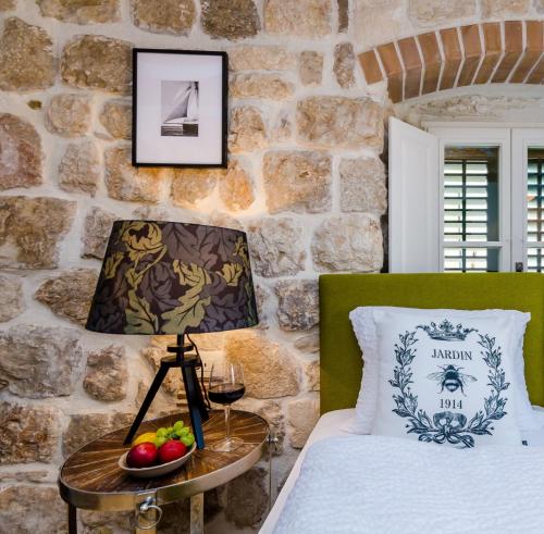 杜布罗夫尼克Villa Monte Santo的一间卧室配有一张床和一张带台灯的桌子