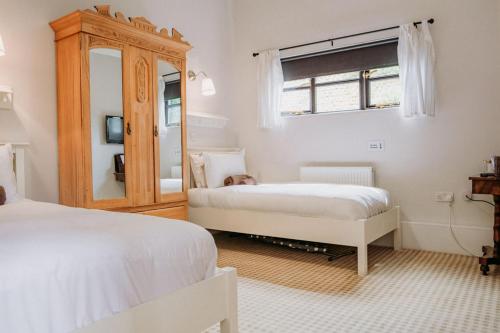 克劳奇河畔伯纳姆Creeksea Place Barns的一间卧室配有两张床和镜子