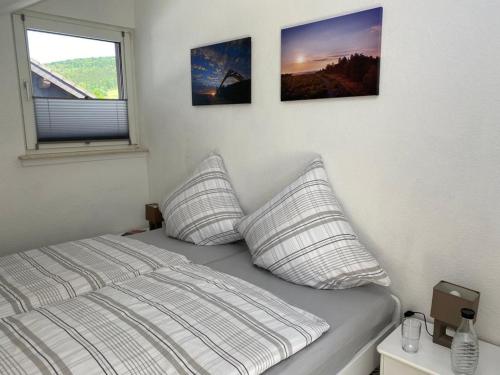 温特贝格Ferienwohnung Frieda mit überdachtem Balkon的卧室配有一张墙上三幅照片的床