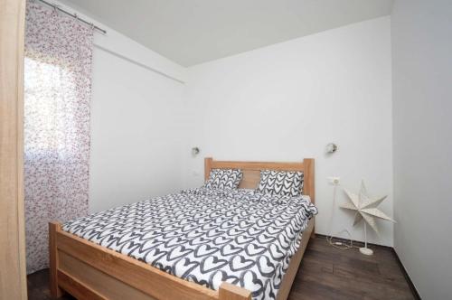 蒂瓦特Apartments Nina Tivat的一间卧室配有一张带黑白色棉被的床