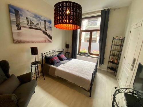 布鲁塞尔Petit Appartement Jourdan EU的一间卧室配有一张床和一个吊灯