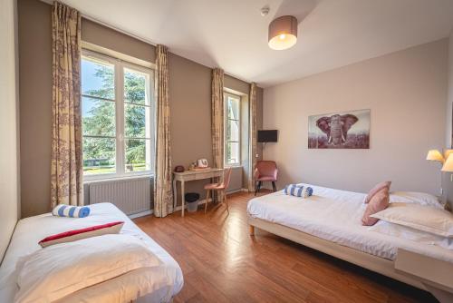 鲁瓦夫杜门鲁瓦费酒店的一间卧室设有两张床、一张桌子和窗户。