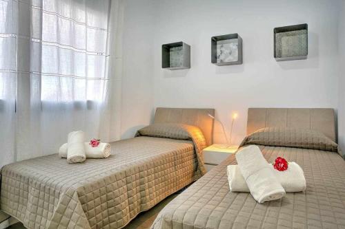 拉奥利瓦La Oliva Luxury House的一间卧室配有两张带毛巾的床