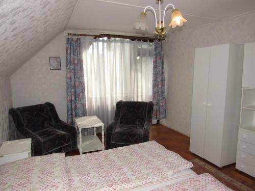 豪伊杜索博斯洛Kossuth Apartman的一间卧室配有一张床和两把椅子
