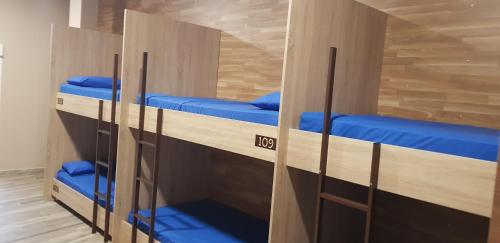 卡尔达斯·德·雷斯albergue a queimada的客房设有三张双层床和蓝色枕头。