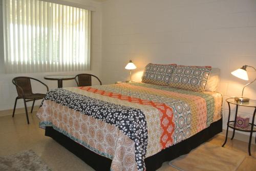博雷戈斯普林斯Borrego Springs Motel的卧室配有一张床和一张桌子及椅子