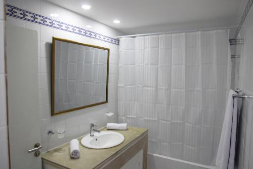 Al ḨaddādahDar ABDELKRIM的一间带水槽、镜子和淋浴的浴室