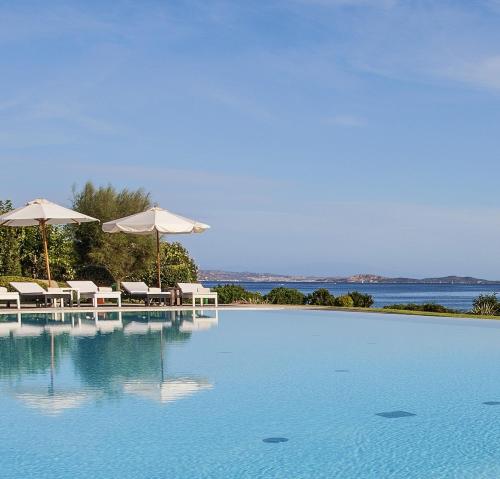 巴哈撒丁岛乐比安卡豪华度假酒店的一个带遮阳伞和椅子的游泳池以及水