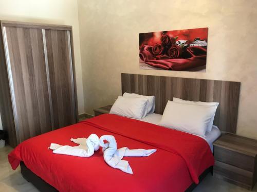 安曼Suzan Hotel Apartments的一间两人卧室,躺在一张红色的床上