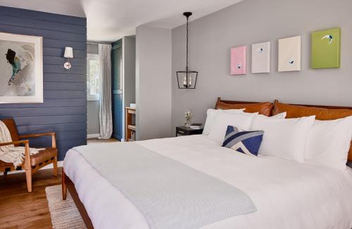 东汉普顿Journey East Hampton的卧室配有白色大床和蓝色的墙壁