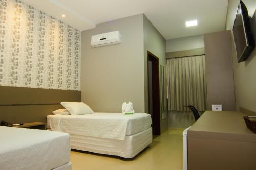 Lucas do Rio VerdeHotel Mandino的酒店客房设有两张床和电视。