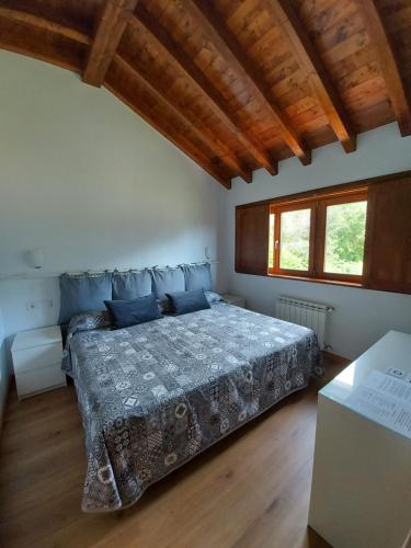 CamangoEl Cuadron的一间带一张床的卧室,位于带木制天花板的房间内