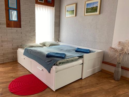 ZlonínU Vrabčáka的红色地毯的房间里一张白色的床