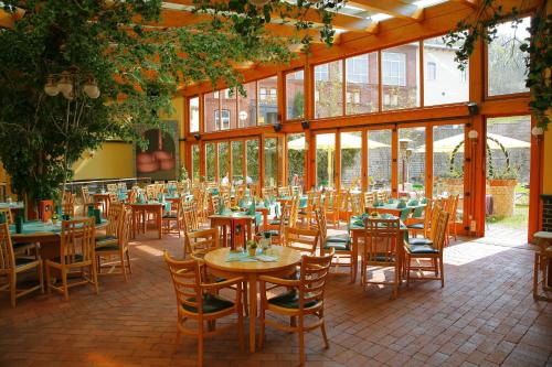 阿恩施塔特阿恩施塔特斯塔德特布瑞恩霍特公园酒店的餐厅设有木桌、椅子和窗户。