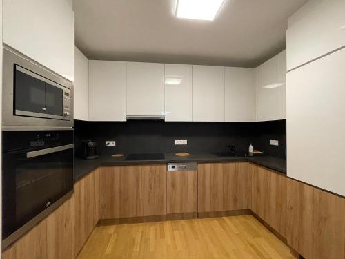 维也纳Modern Danube Apartment Vienna的厨房配有黑白橱柜和微波炉