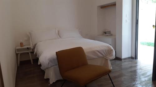 圣维托基耶蒂诺Relais FraSimon Antico Casale的卧室配有白色的床和椅子