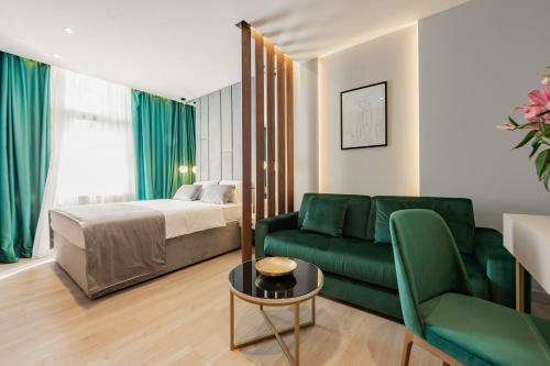 斯普利特Caldo Luxury Rooms的客厅配有绿色沙发和床。