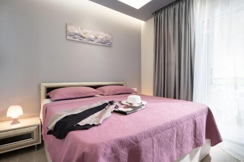 托罗尼Leonardo Apartamente的一间卧室配有粉红色的床,上面有托盘