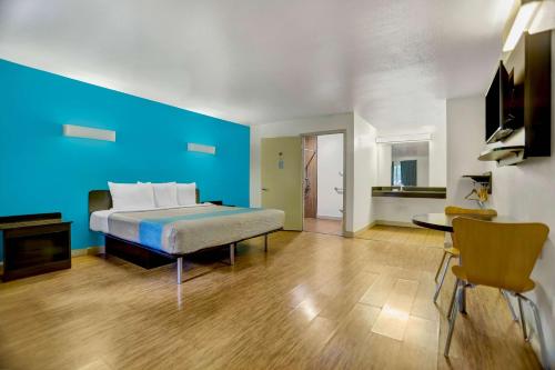 安德森安德森6号汽车旅馆的一间卧室设有一张床和蓝色的墙壁