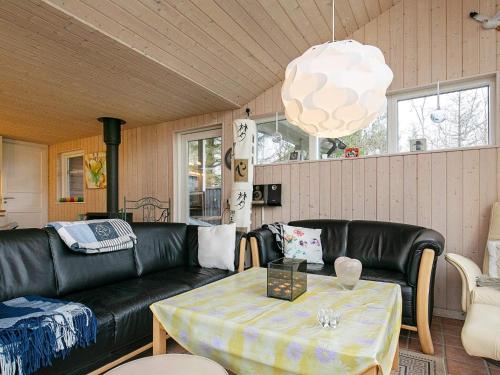 乌尔夫堡6 person holiday home in Ulfborg的客厅配有黑色真皮沙发和桌子