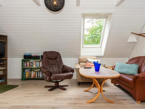 埃贝尔托夫特6 person holiday home in Ebeltoft的客厅配有两把椅子和一张桌子