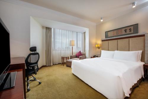 北京北京中成天坛假日酒店的酒店客房设有一张白色大床和一张书桌