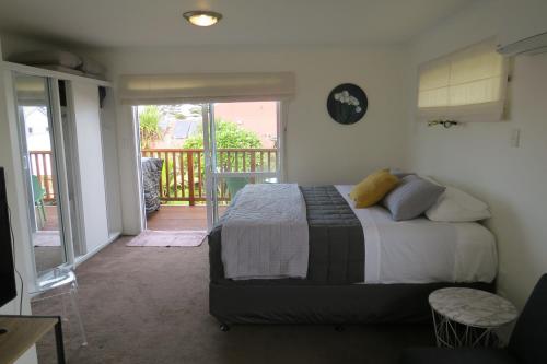吉斯伯恩Two Palms的一间卧室设有一张床和一个阳台