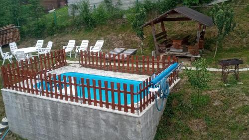 斯拉夫西克Біля лісу Шале з двома спальнями的一个带椅子的游泳池和一个凉亭