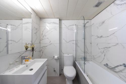 利马索尔Odysseia Hotel Kapetanios的白色的浴室设有卫生间、浴缸和水槽。