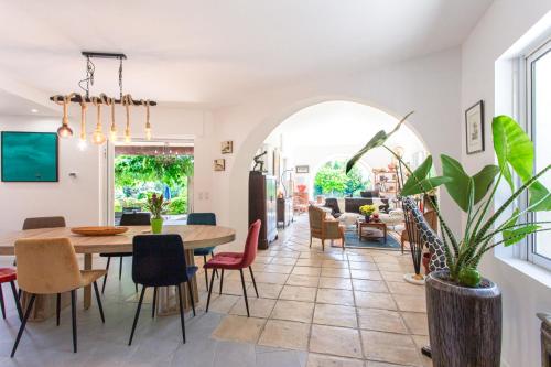 PlascassierLe Domaine des Mûriers - charme, chic, calme en Provence Côte d'Azur的用餐室以及带桌椅的起居室。