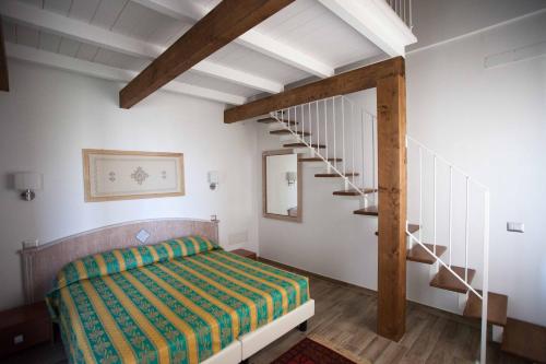 托尔托利Locanda degli Artisti的一间卧室设有一张床和一个螺旋楼梯