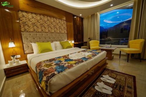 马拉里Abhilashi Residency & Spa - Centrally Heated & Air Cooled的一间卧室设有一张大床和一个大窗户