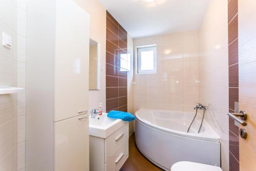 梅杜林Dragan K1的白色的浴室设有浴缸和水槽。